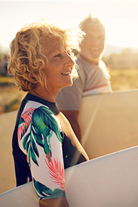 Mature lady holding a surf board Golden Leaves