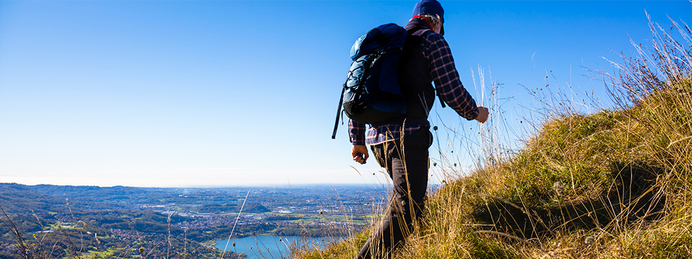Man hiking on a picturesque mountain side funeral plans uk