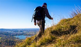 Man hiking up picturesque hillside with views