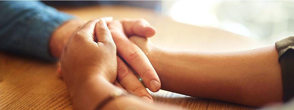 Hand reaching across a table and making contact