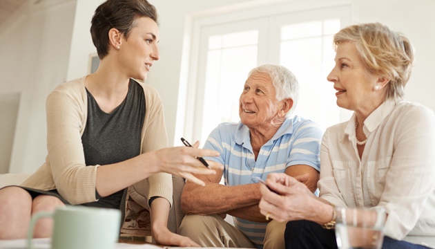 Senior couple taking advice from a young lady