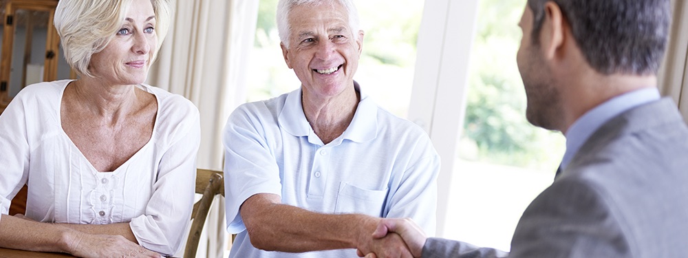 Couple shake hands with a business man