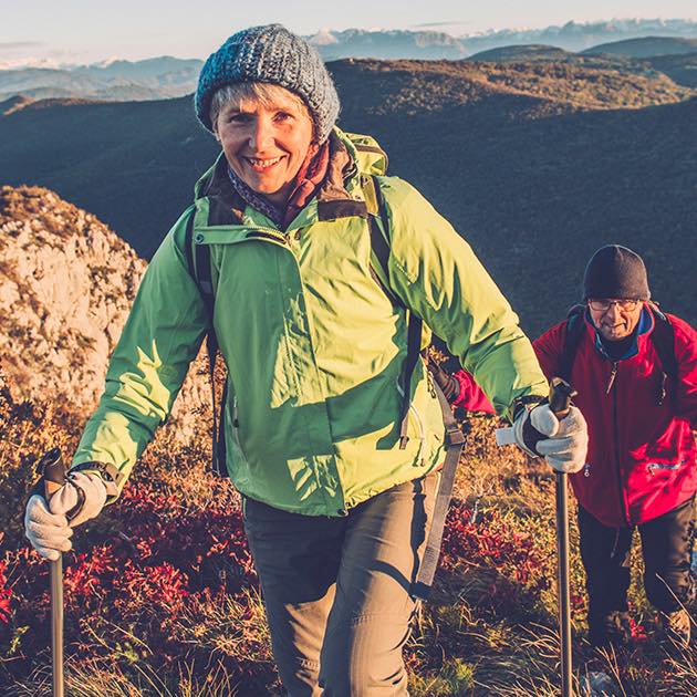 Woman happily hiking up a mountain