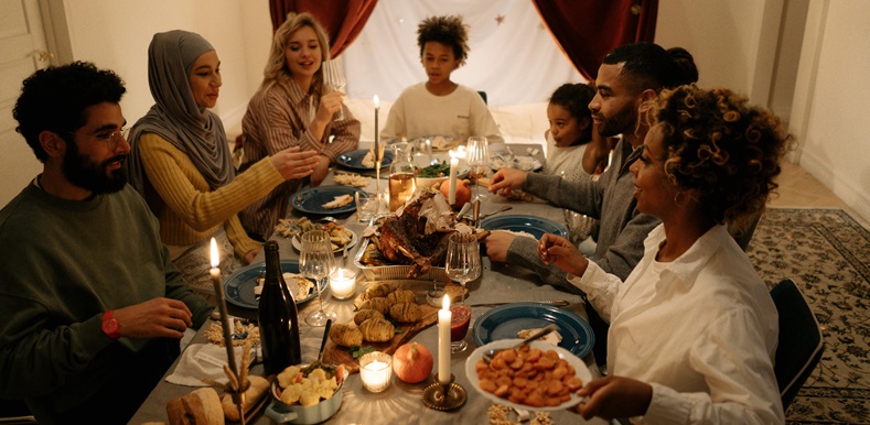 Family sat at  table eating dinner