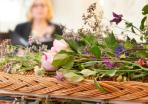 Wicker coffin adorned with delicate funeral flowers