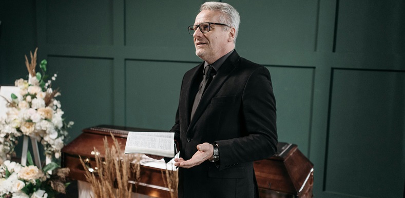 A Man Standing Near a Coffin
