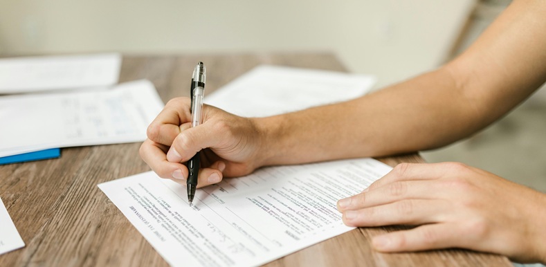 Close-Up Shot of a Person Filling Out a Form