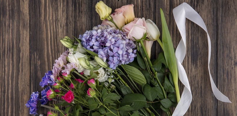 top view of flower bouquet with twine on wooden background