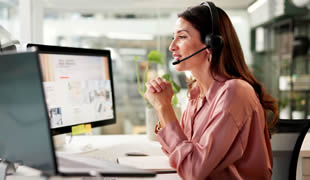 Friendly woman supporting customers over the phone